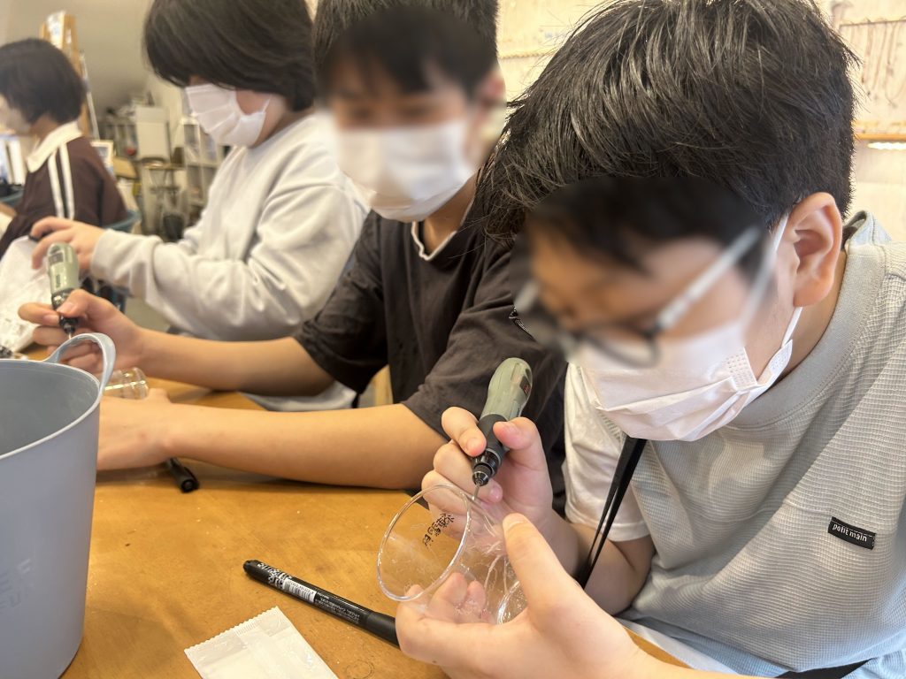 埼玉県所沢市にあるフリースクール、クラーク国際中等部所沢キャンパスで行った、彫り絵グラス作り体験の様子